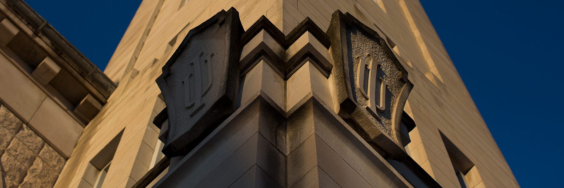 Close up of the IU trident carved in stone on a limestone building