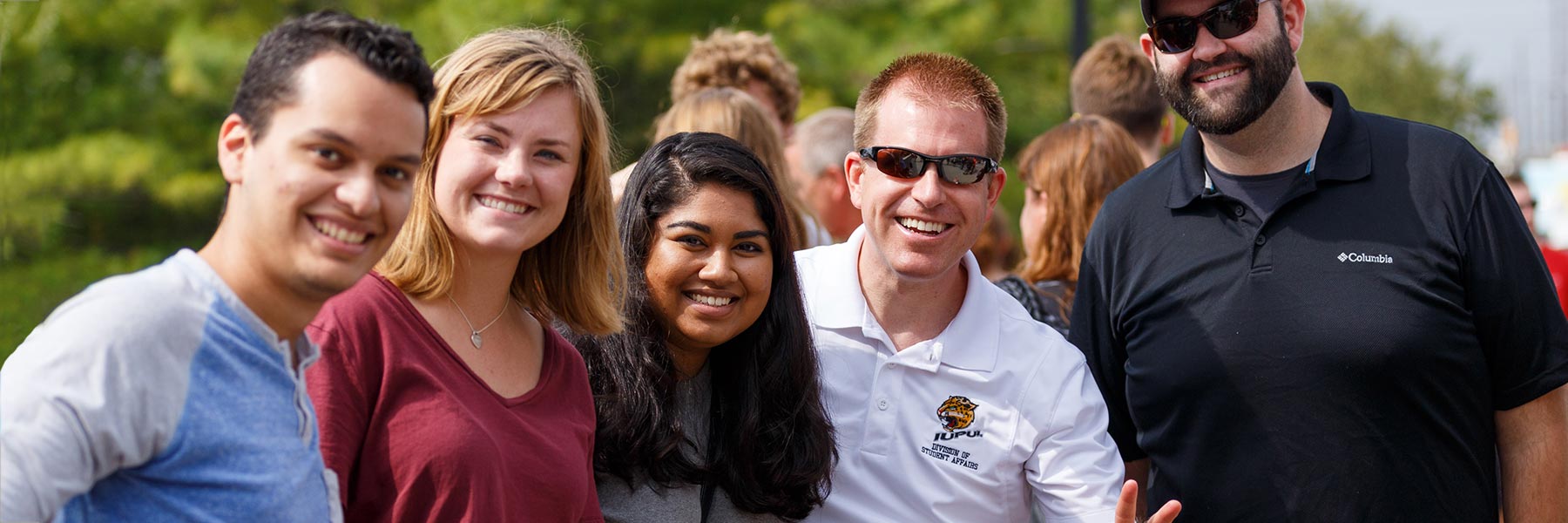 A group of people stand side by side smiling at the camera