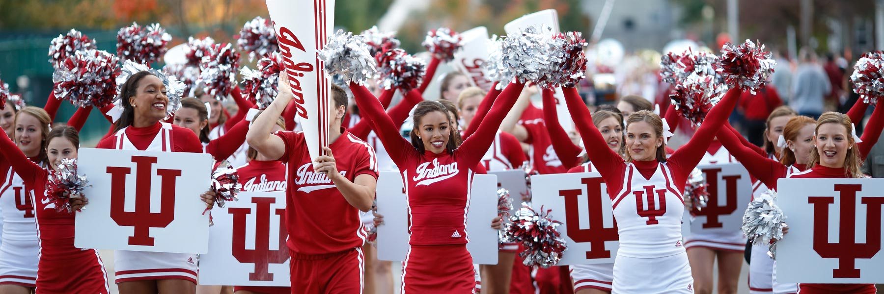 IU cheerleaders in uniform cheer in a line